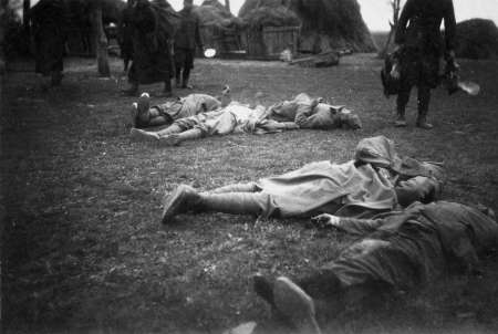 grainy B&W image of covered dead bodies in the field from circa 1942